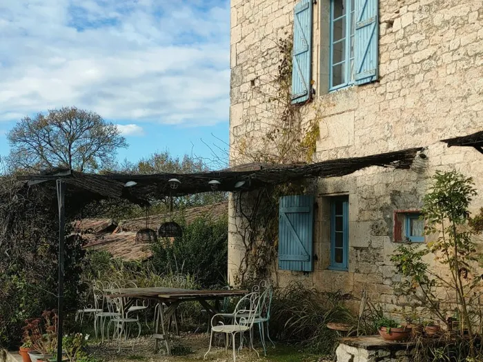 La maison en pierre aux volets bleus et sa terrasse ombragée
